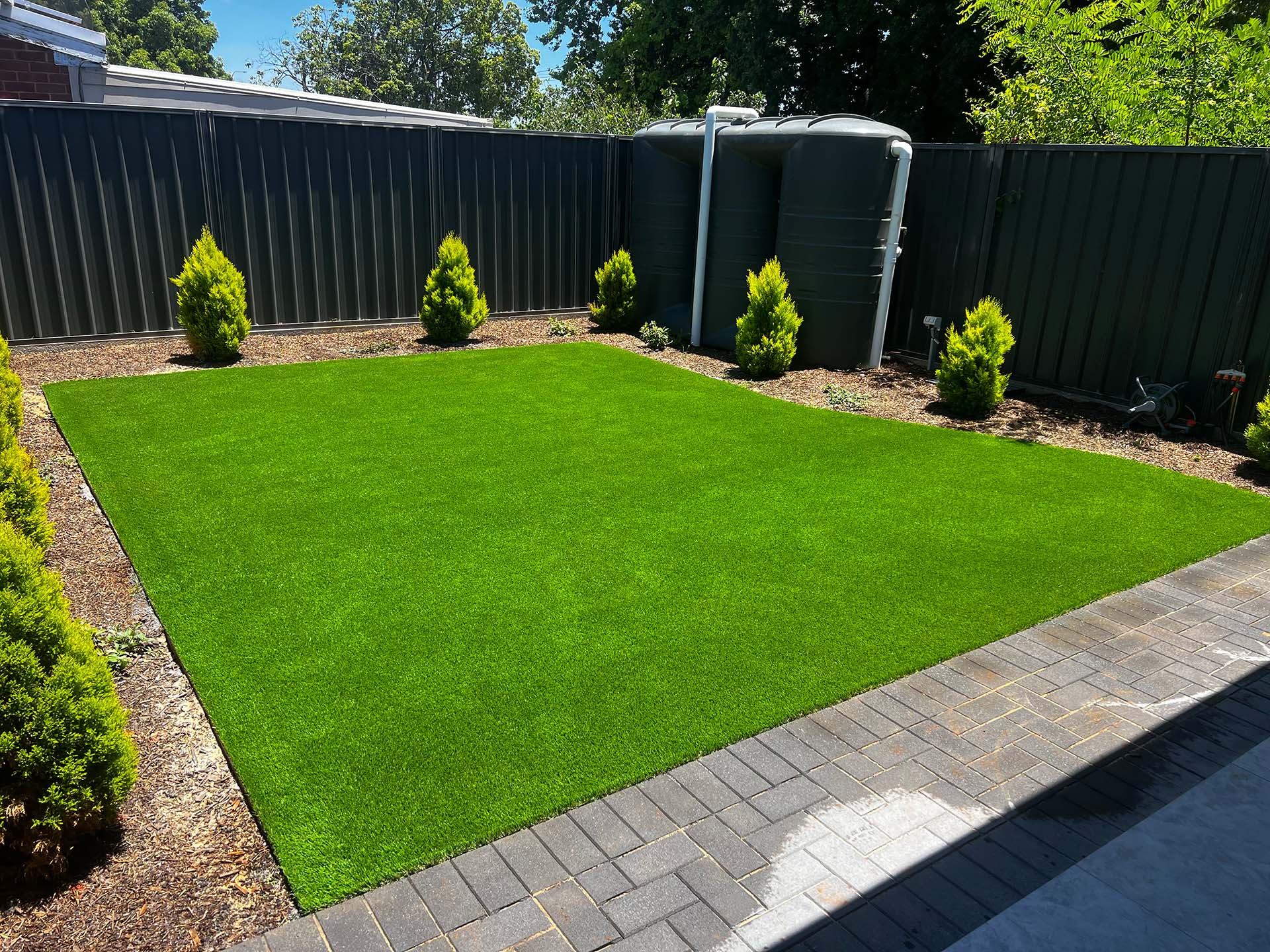 a square of artificial turf in a backyard