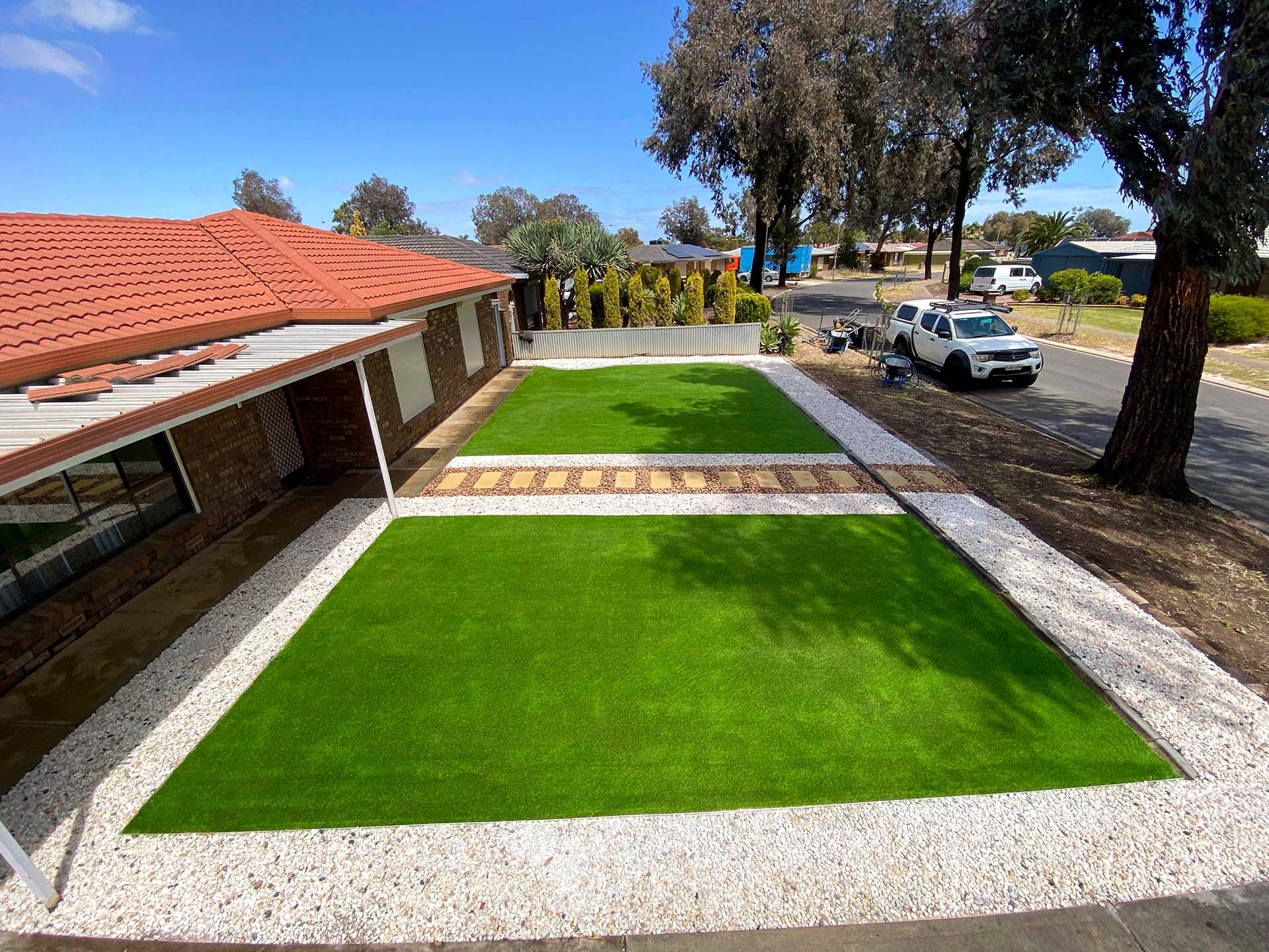 artificial turf in a front garden with a paved walkway down the centre