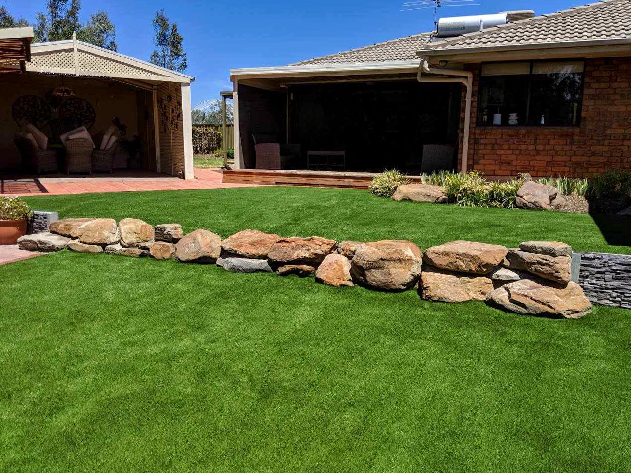 a multi level backyard with artificial turf