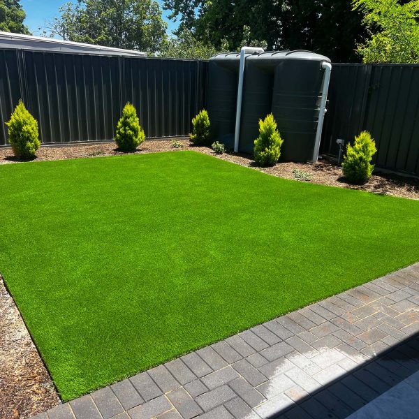 a square of artificial turf in a backyard