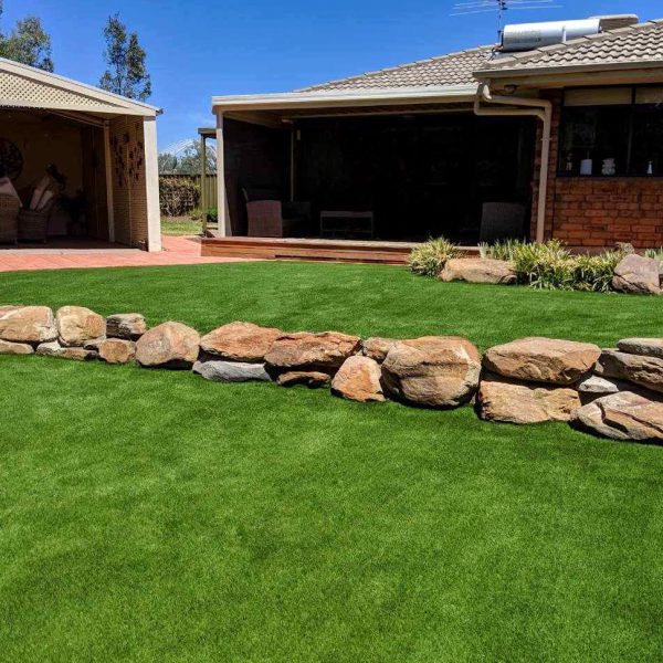 a multi level backyard with artificial turf